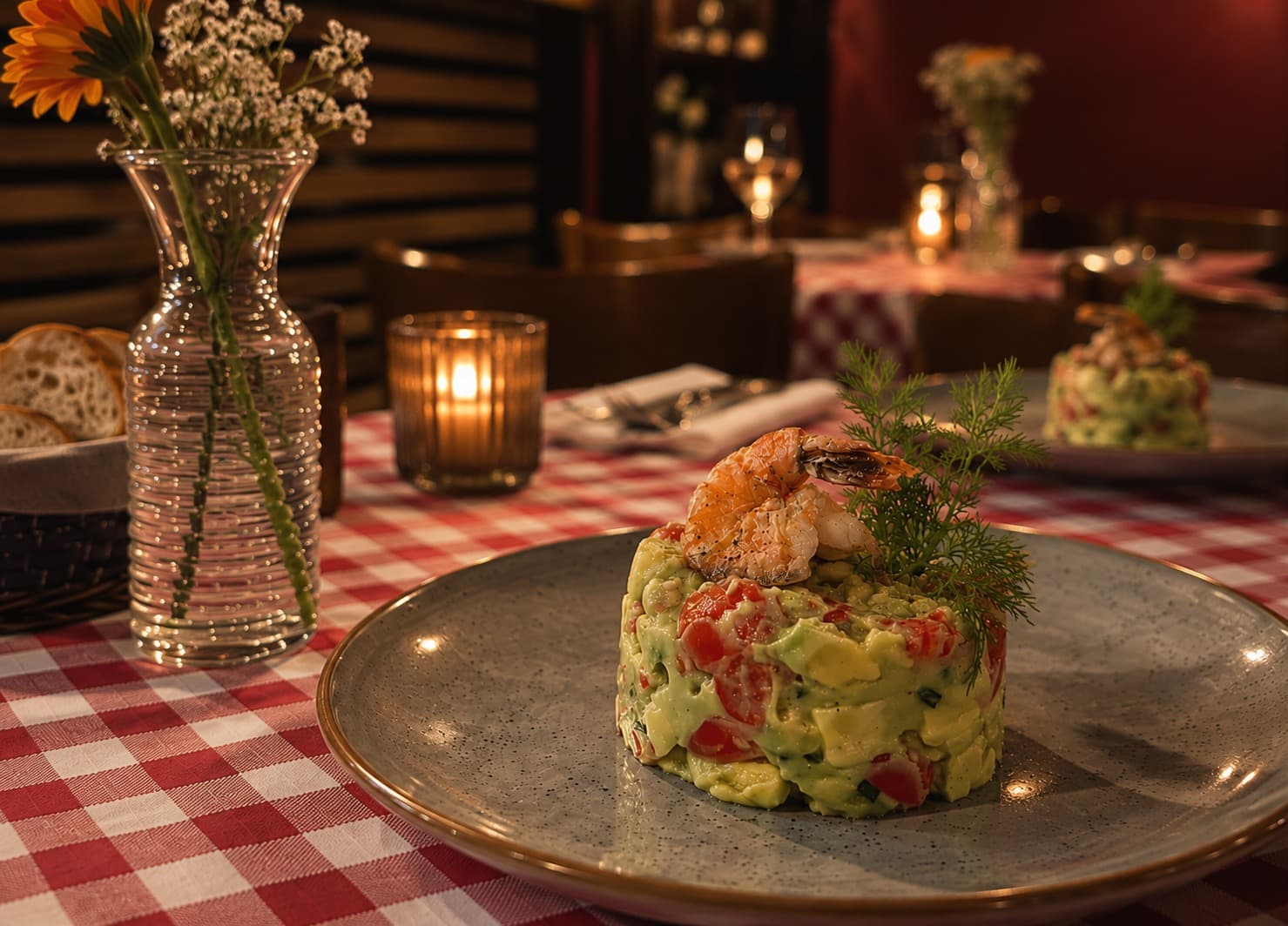 Garnelen-Avocado-Tatar auf einem Tisch bei Kerzenlicht