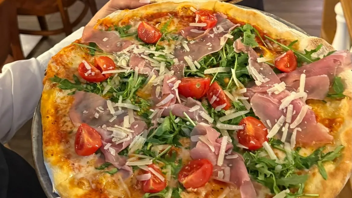 Pizza Parma mit Parmaschinken, Rucola, Cherrytomaten und Parmesan in der Trattoria Che Fame in Berlin-Steglitz